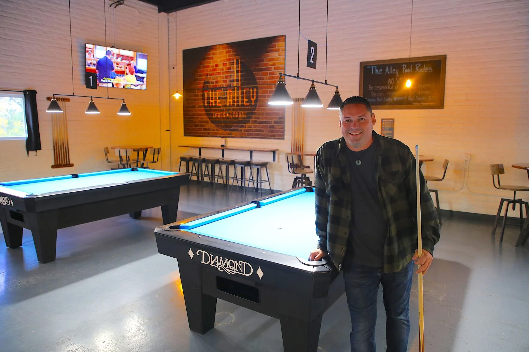 Owner Joey Padilla leans against one of the new Diamond Billiard Product tables he recently installed at The Alley in Santa Fe.  Mike Easterling/The New Mexican